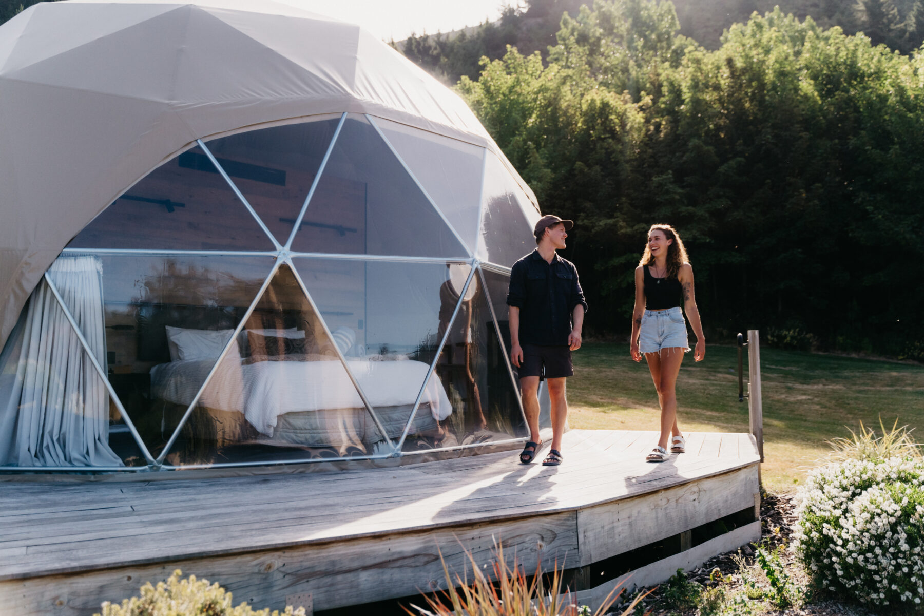 Male & female couple on the deck of Cross Hill Geodome accommodation in Lake Hawea, NZ